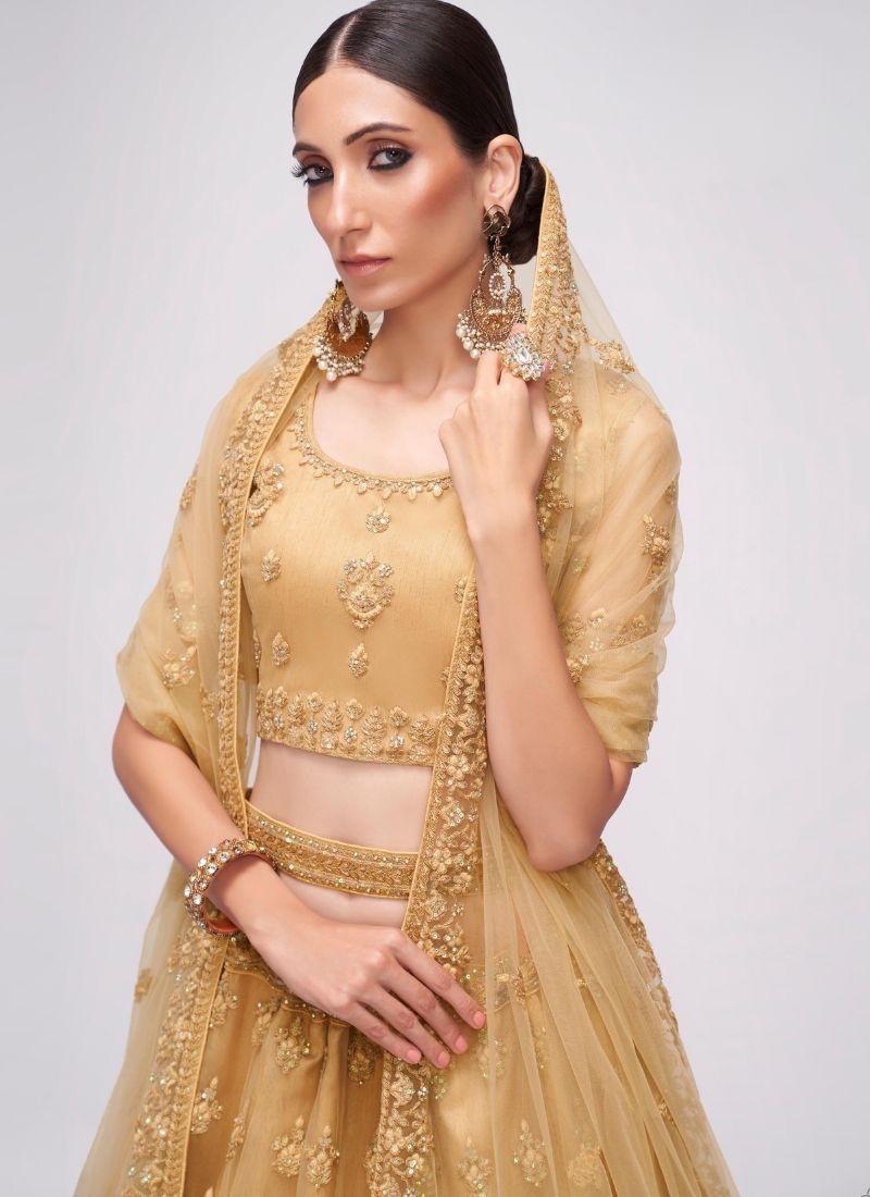 Designer stonework embroidered net lehenga choli in golden